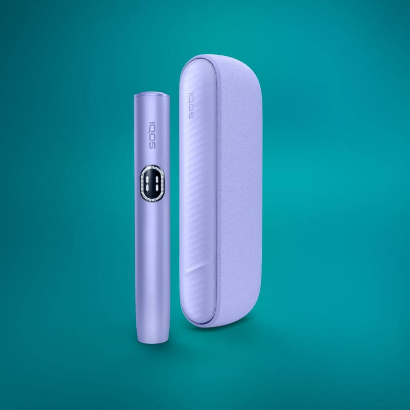 The image shows two IQOS ILUMA i Kits, one standing upright and the other lying horizontally, in a digital violet color.