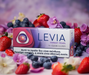 Levia Forest Pearl vape device packaging surrounded by strawberries, blueberries, and flowers on a blurred background