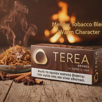 A box of Terea Bronze mellow tobacco blend for 100S Ilima, styled on a rustic wooden table with cinnamon sticks, star anise, and a bowl of loose tobacco with rising steam. The background features a warm, blurred fire, and text overlays read 'Mellow Tobacco Blend Warm Character'.