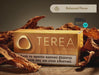 A box of TERA Yellow 4000 ILUMA tobacco product sits on a wooden surface surrounded by dried brown tobacco leaves. The box is golden yellow with the brand name 'TEREA' in large white letters and a health warning band at the bottom.